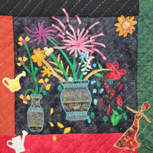 Fiber art quilt featuring embroidered flowers in vases, colorful accents, and a dancing figure.