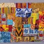 Fiber art quilt featuring colorful batik fabrics and African-inspired textile patterns in a patchwork collage.