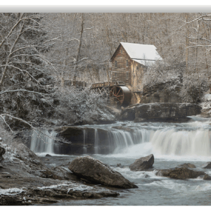 Photograph of Glade Creek Grist Mill with snow-dusted trees and rushing creek in West Virginia.