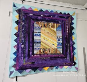 Quilts featuring prairie point binding with folded fabric triangles creating a textured, dimensional edge around the border.